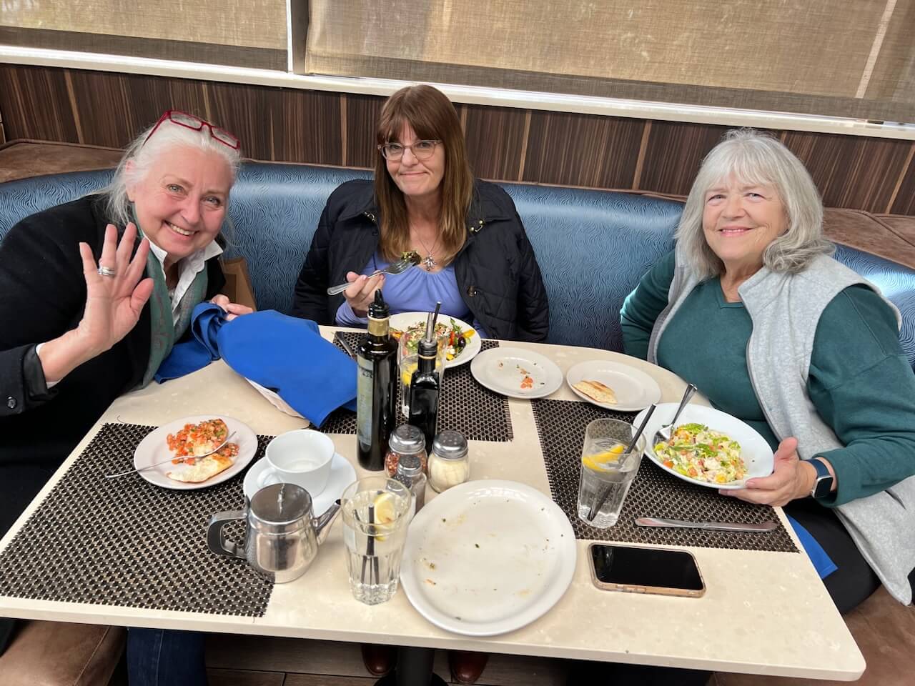 Three members sitting in a booth at Spruzzos